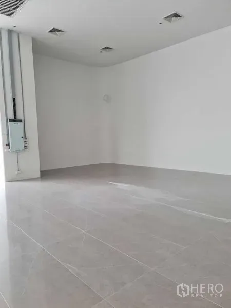 Retail Space for rent - Empty white-box retail interior with high ceiling and polished tile flooring ready for fit-out.