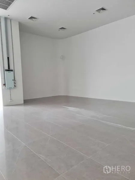 Retail Space for rent - Empty white-box retail interior with high ceiling and polished tile flooring ready for fit-out.