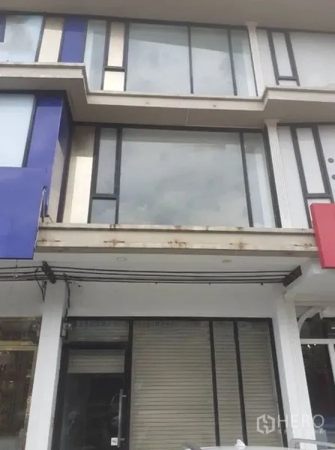 Shophouse for rent - Upper floors of a modern shophouse featuring large glass panels and clean geometric lines above the shopfront.