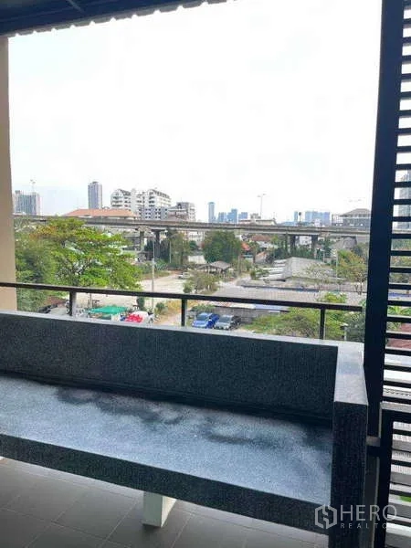 Townhouse for rent in Khlong Toei, Bangkok - Balcony with built-in bench overlooking Sukhumvit skyline and elevated roadway.