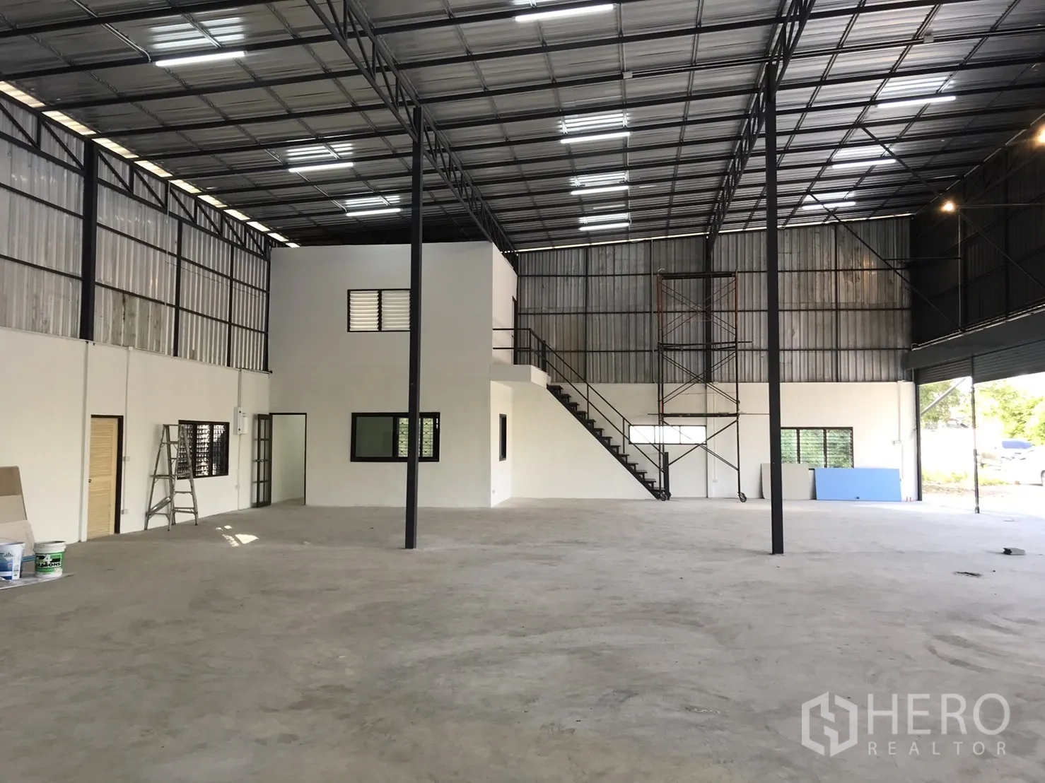Warehouse for rent in Lam Luk Ka, Pathum Thani - Spacious warehouse interior with high steel roof, mezzanine office and staircase.
