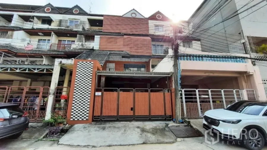 Townhouse for rent or sale in Suan Luang, Bangkok - Row townhouse facade in Suan Luang with folding wooden gates.