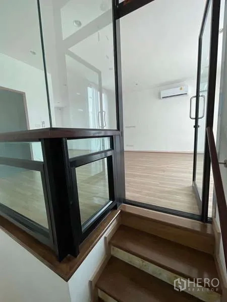 带办公室的家 出租或出售在Wang Thonglang, Bangkok - 玻璃围合的楼梯平台与木质台阶通往楼上