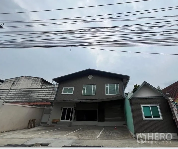 Warehouse for rent in Prawet, Bangkok - Front elevation of the warehouse with wide driveway and marked parking bays.