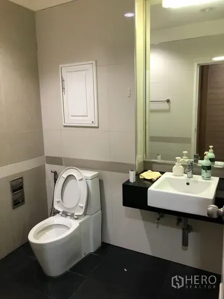 Shophouse for rent - Modern tiled bathroom with large mirror, square basin and toilet.