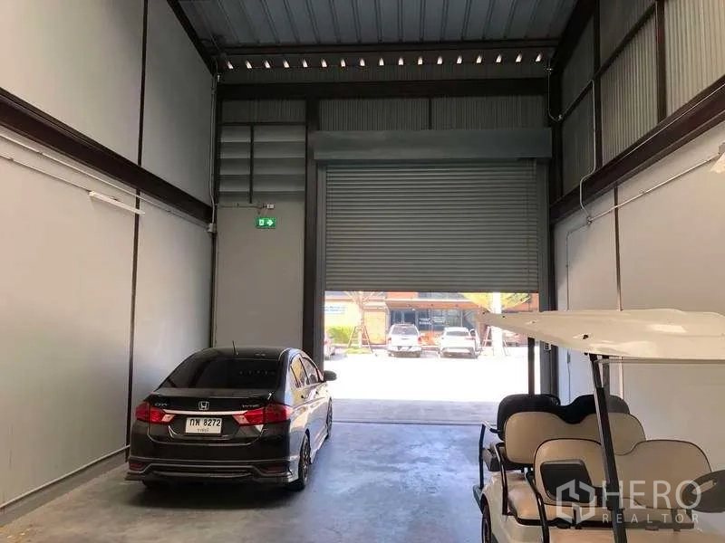 Warehouse for rent in Bang Phli, Samut Prakan - Interior view toward a high-clearance roller shutter door for easy truck access.