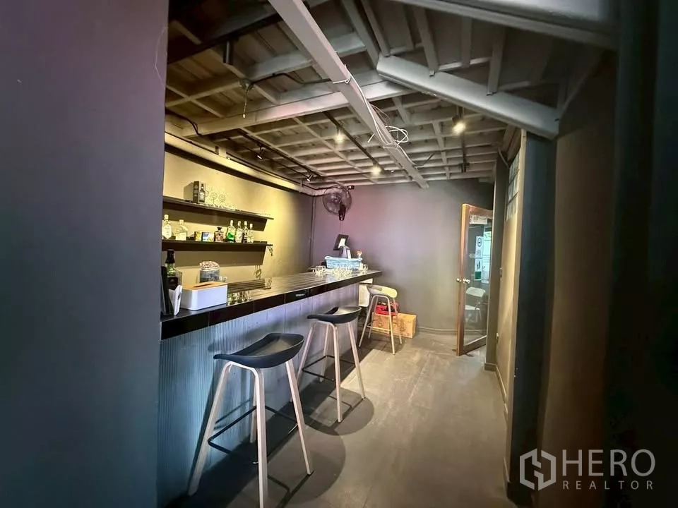 Retail Space for rent in Watthana, Bangkok - Indoor bar counter with stools, wall shelving and track lighting.