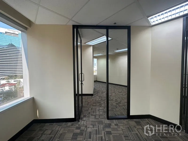 Office Space for rent - Corner office area with windows, glass doors and views of the Bangkok skyline.