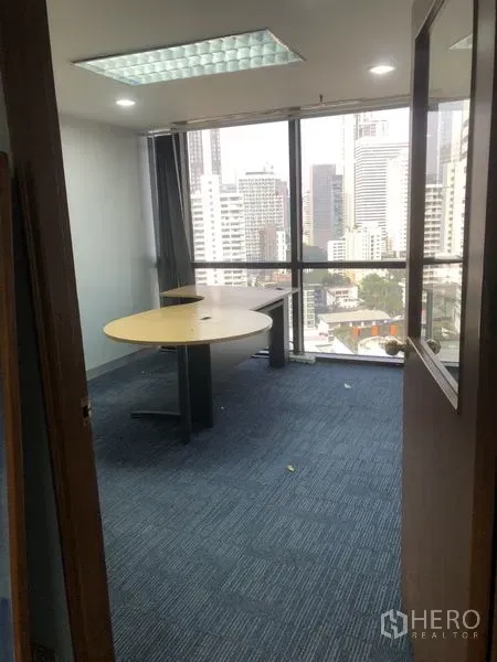 Office Space for rent - Private corner office with round table, blue carpet, and floor-to-ceiling windows overlooking the Bangkok skyline.