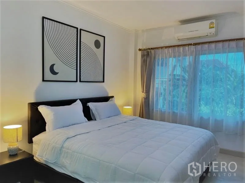 Detached House for rent in Suan Luang, Bangkok - Cozy view of the master bedroom showcasing bed, wall art and warm lamps.