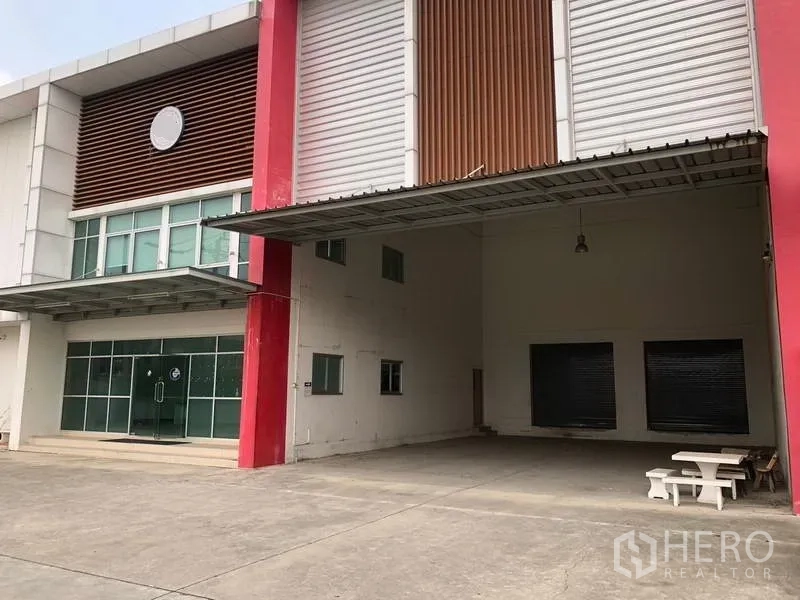 工厂 出租在Bang Sao Thong, Samut Prakan - 有顶装卸区，配高位卷帘门和宽阔混凝土场地。