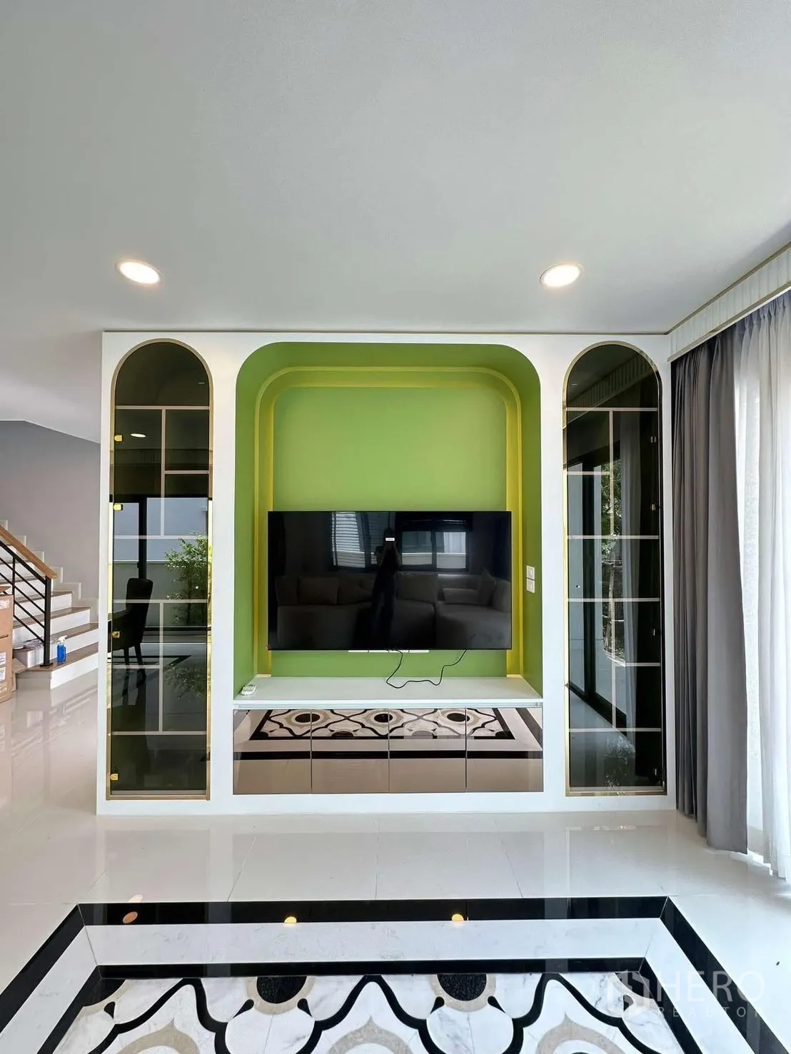 Detached House for rent in Bang Phli, Samut Prakan - TV wall with large screen set in a green niche and display cabinets.