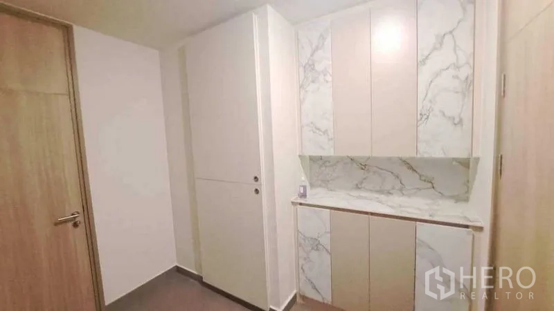 Condominium for rent or sale in Pathum Wan, Bangkok - Entry hall with marble-look built-in cabinetry providing extra storage.