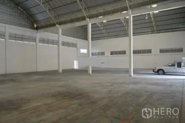 货栈 出租在Samut Sakhon - 开放存储区，层高高，宽阔混凝土地面，靠近卷闸门区域。