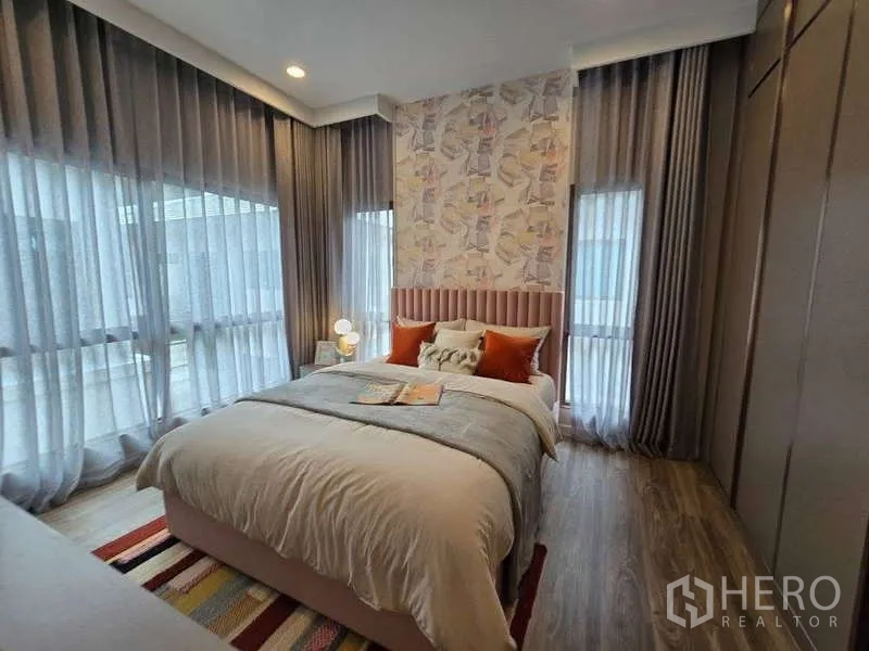 Detached House for rent in Bang Kapi, Bangkok - Cozy third bedroom with patterned accent wall and corner windows.