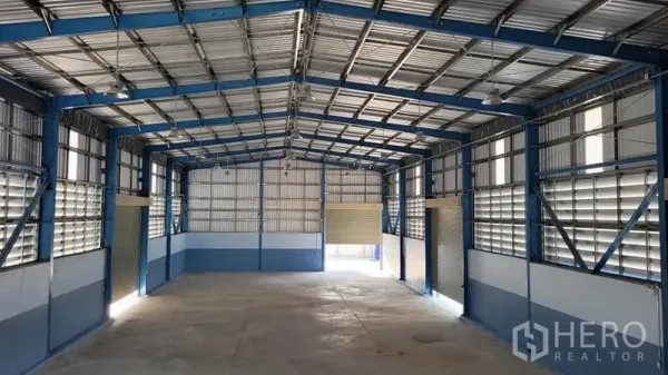 Factory for rent or sale in Phanat Nikhom, Chon Buri - Secondary warehouse bay with louvered ventilation panels and roller shutters.