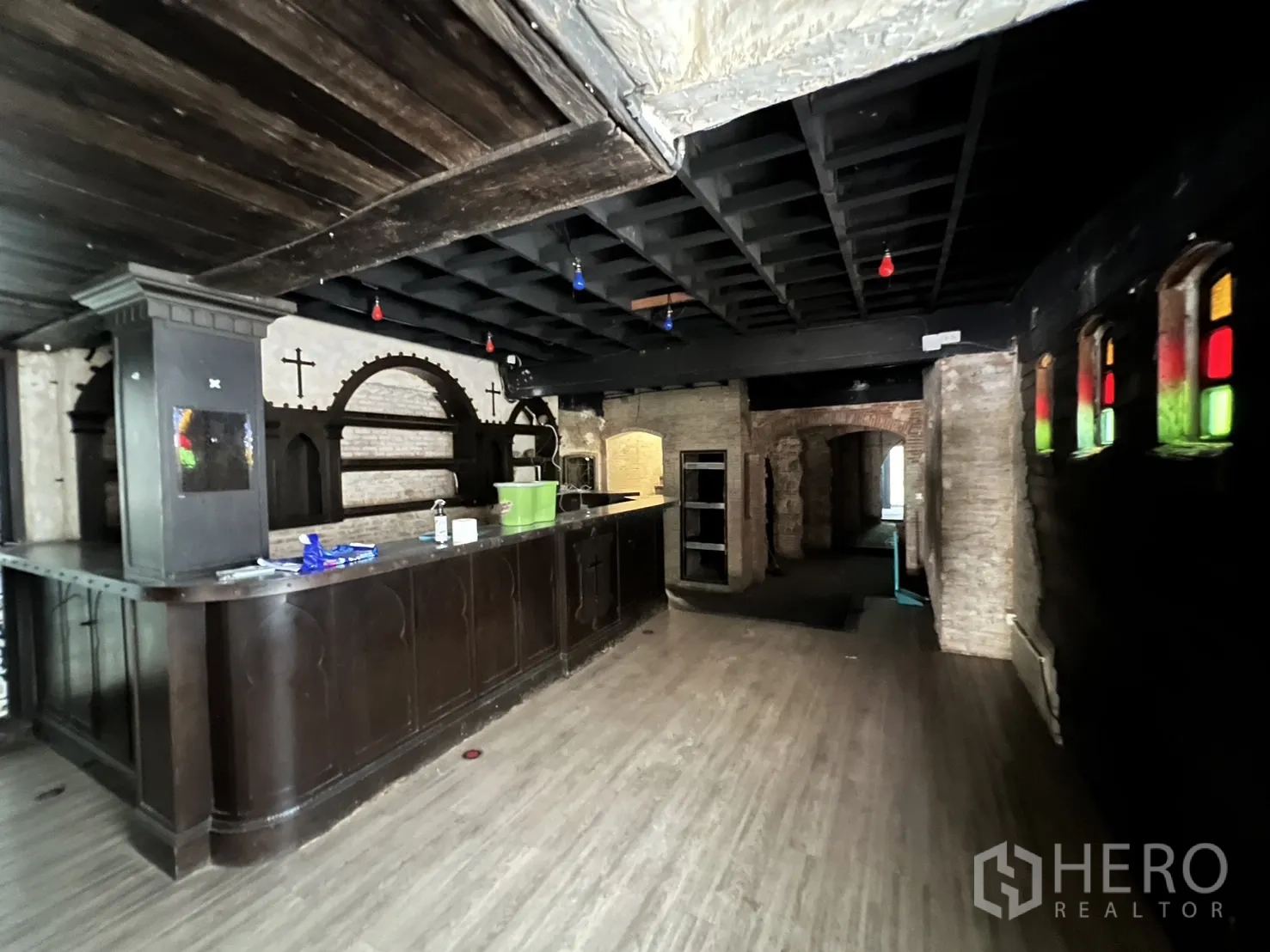 Retail Space for rent in Watthana, Bangkok - Wooden bar counter in a room with dark ceiling and arched brick detailing.