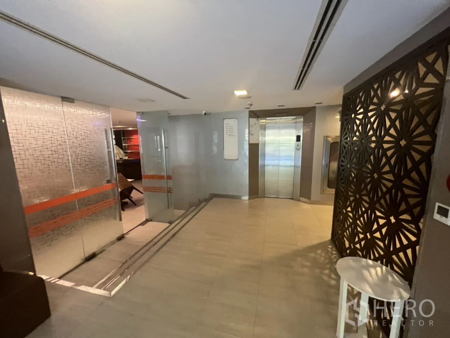 Retail Space for rent in Khlong Toei, Bangkok - Lobby with glass doors, elevator and patterned privacy screens.