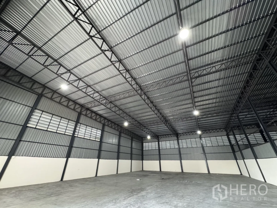 Warehouse for rent in Phra Nakhon Si Ayutthaya, Phra Nakhon Si Ayutthaya - Spacious warehouse interior in Bang Pa-in with high steel truss roof, LED lights, and polished concrete floor.