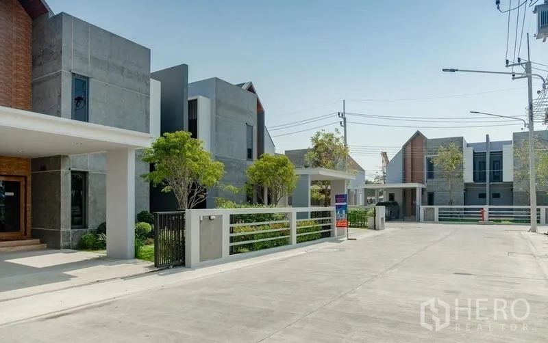 Detached House for sale in Lam Luk Ka, Pathum Thani - Internal project road lined with modern houses and front fences.