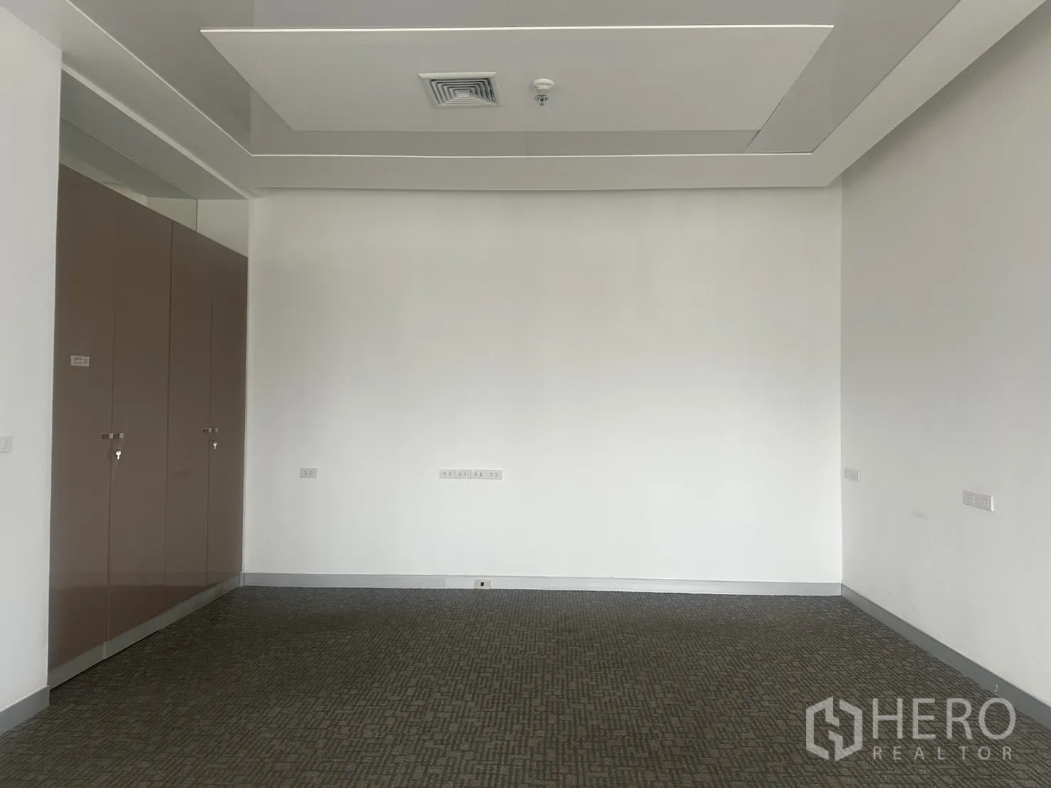 Office Space for rent in Khlong Toei, Bangkok - Private office space with carpet flooring, ceiling air vent, and tall storage cabinets.
