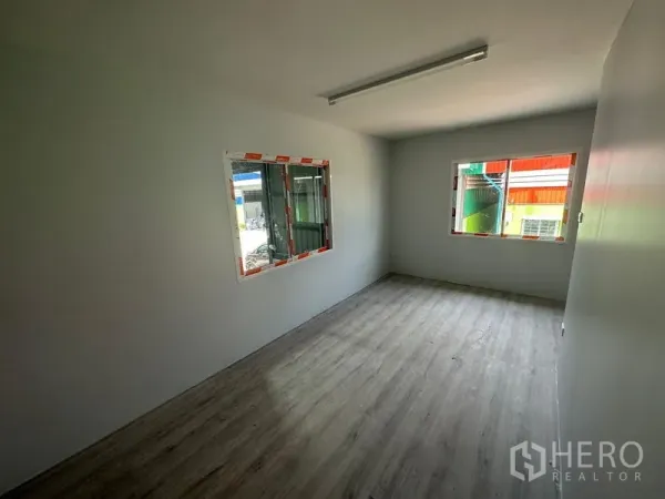 Warehouse for rent in Khlong Toei, Bangkok - Bright office room with two windows and wood-style flooring inside the warehouse.