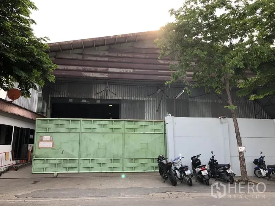 Warehouse for rent in Lak Si, Bangkok - Steel warehouse exterior in Lak Si, Bangkok with a large green sliding gate and street frontage.