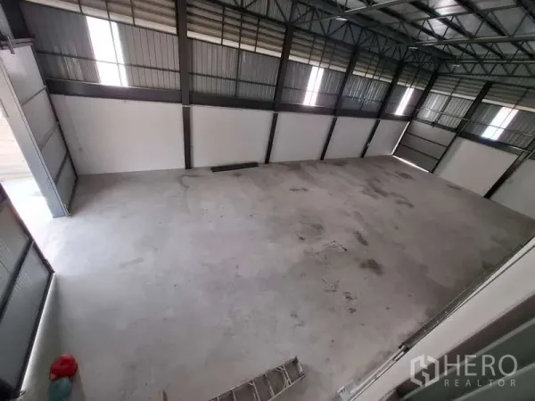 Warehouse for rent or sale in Bang Phli, Samut Prakan - Large open warehouse floor with high ceiling and skylights viewed from mezzanine.