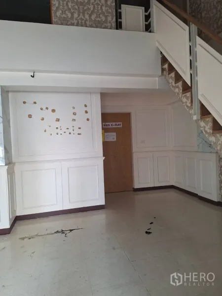 Retail Space for rent in Watthana, Bangkok - Ground-floor area with staircase and wood door, classic wall panels ready for refit.