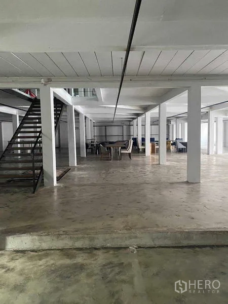 Retail Space for rent in Bang Na, Bangkok - Open-plan level with a metal staircase and tables in the distance.