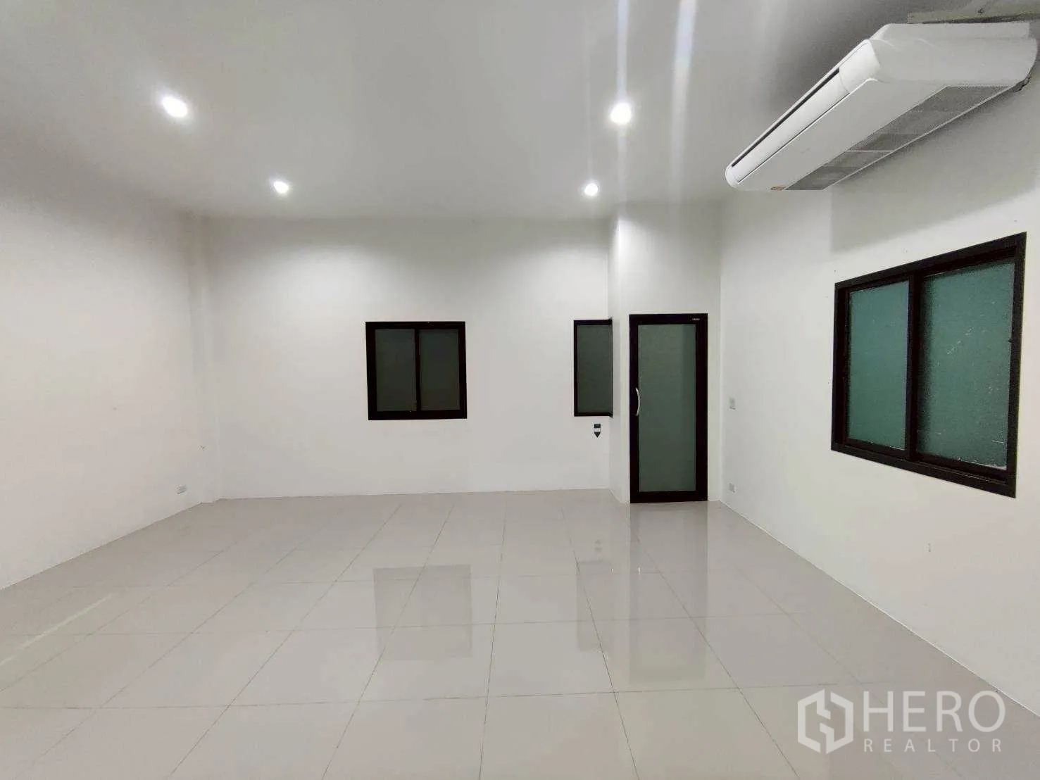 Warehouse for rent in Lam Luk Ka, Pathum Thani - Bright office interior with AC unit, frosted windows, and a glass door.