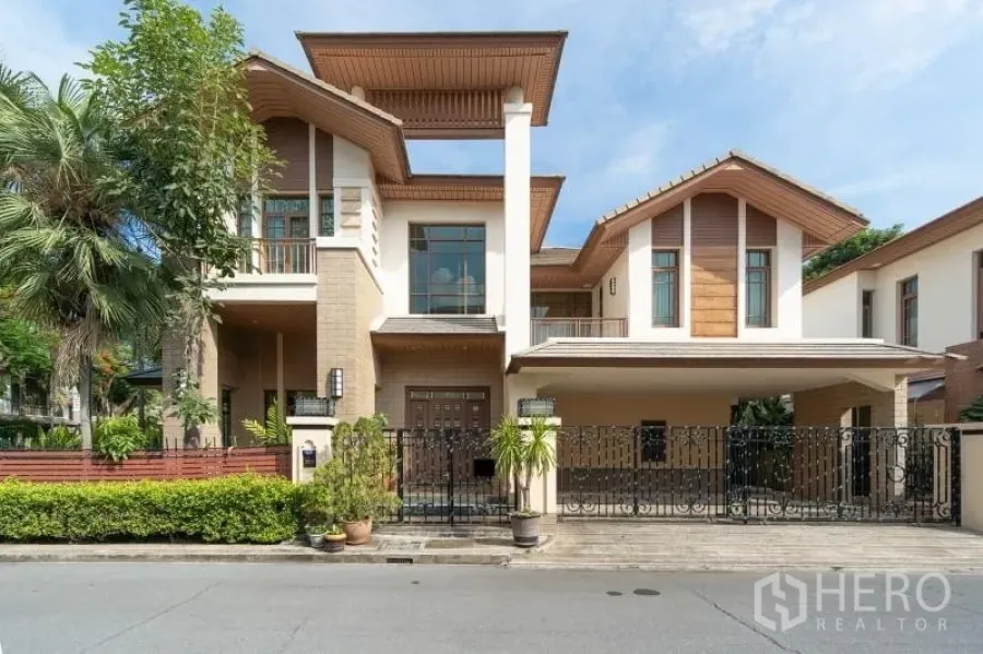 Detached House for rent in Watthana, Bangkok - Modern detached house facade with gated parking, balconies and landscaped frontage.