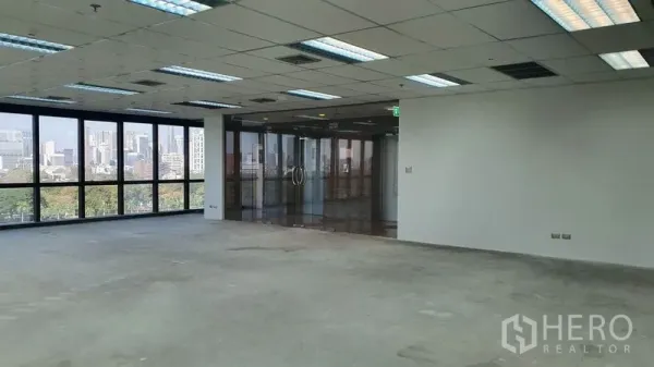 Office Space for rent in Watthana, Bangkok - Spacious office interior with city-view windows and a full glass entry wall.