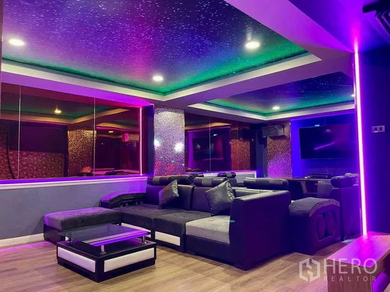 Shophouse for rent in Lat Phrao, Bangkok - Colorful entertainment room with mirrored wall, sofas and ambient LED lighting.