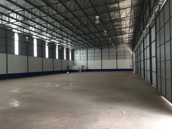 货栈 出租在Pathum Thani - 宽大的仓库大厅，排布高天棚灯与采光带，地面平整。