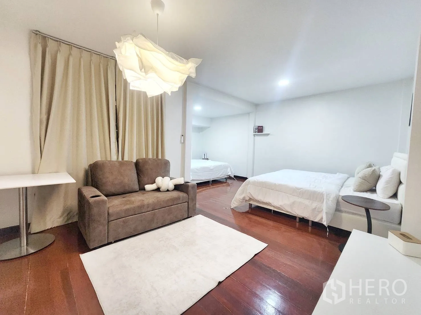 Detached House for rent in Huai Khwang, Bangkok - Spacious room with two beds, a sofa, area rug, and hardwood floors.