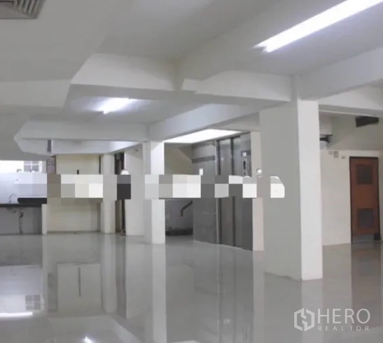 店屋 出租在Khlong Toei, Bangkok - 一层明亮的开放式空间，抛光地砖、承重立柱与电梯前厅。