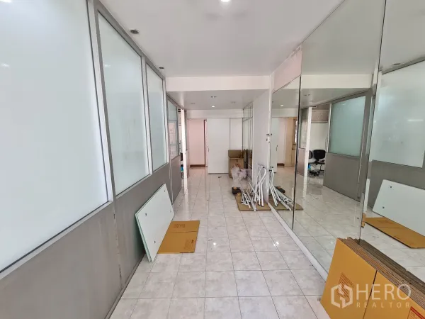 Shophouse for rent or sale in Sathon, Bangkok - Long interior hallway with mirror wall, recessed lighting and frosted partitions ready for fit-out.