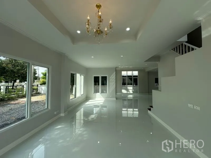 Detached House for sale in Lam Luk Ka, Pathum Thani - Dining space with chandelier, large windows and garden outlook.