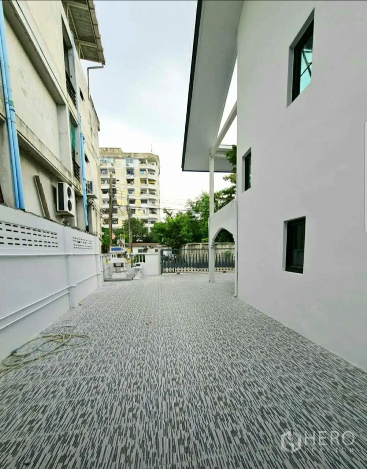 Home Office for rent in Lat Phrao, Bangkok - Long tiled driveway along boundary wall leading to the main gate.