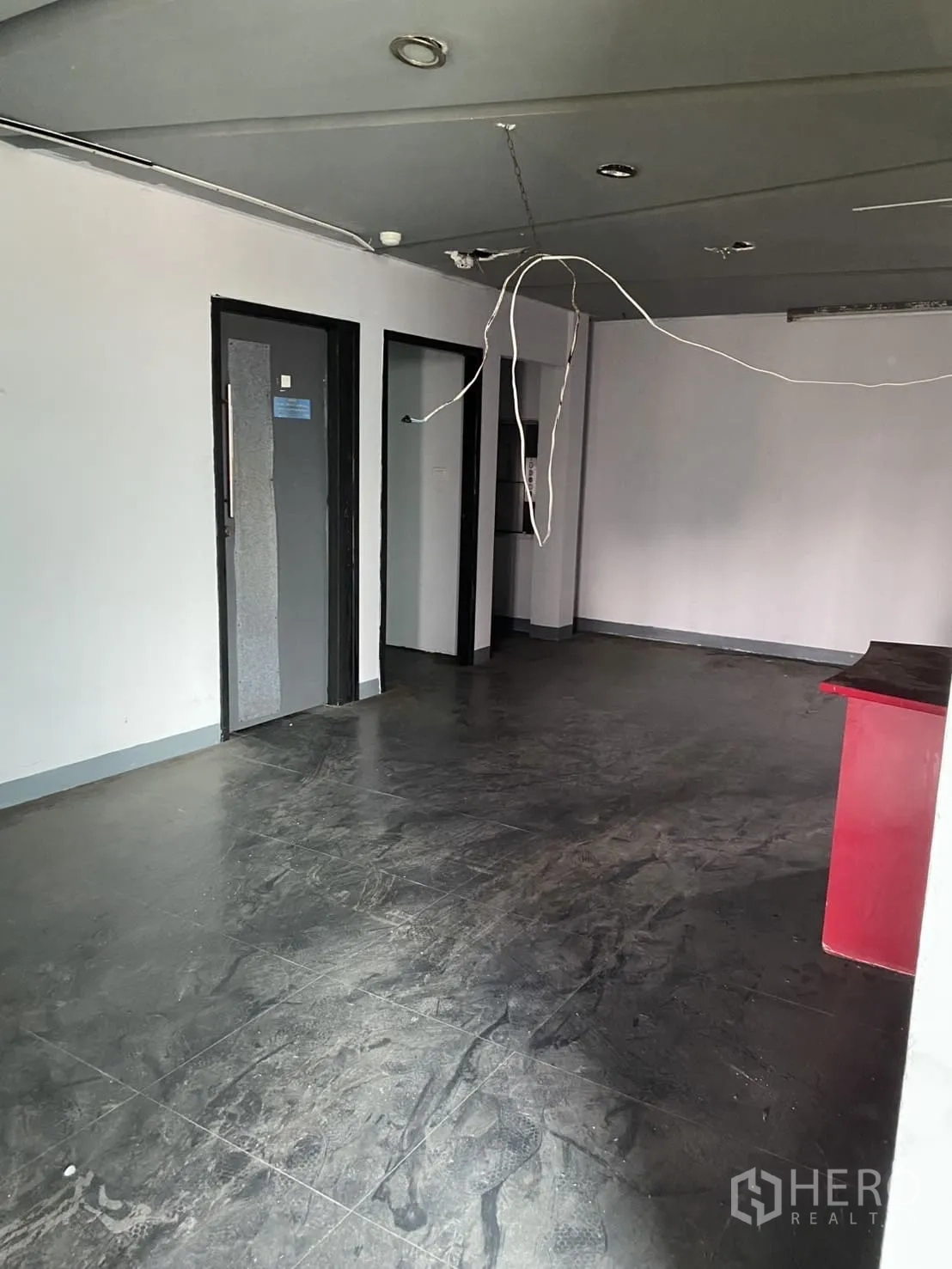 Showroom for rent in Lat Phrao, Bangkok - Open-plan room with dark tile flooring and ceiling lighting, ideal for office or showroom use.