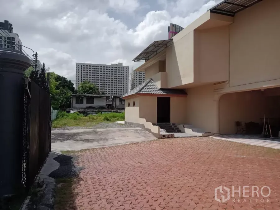 Detached House for rent in Phaya Thai, Bangkok - Paved courtyard and side of a two-storey detached house with city skyline in Phaya Thai.