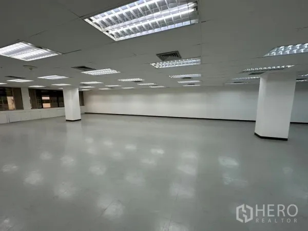 Office Space for rent in Watthana, Bangkok - Large empty office floor with grid ceiling lights, white walls, grey vinyl flooring and structural columns.