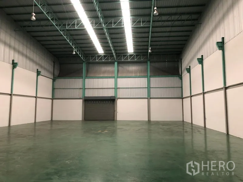 工厂 出租在Samut Prakan - 仓库内部，钢桁架、LED灯带与卷帘门，层高通透。