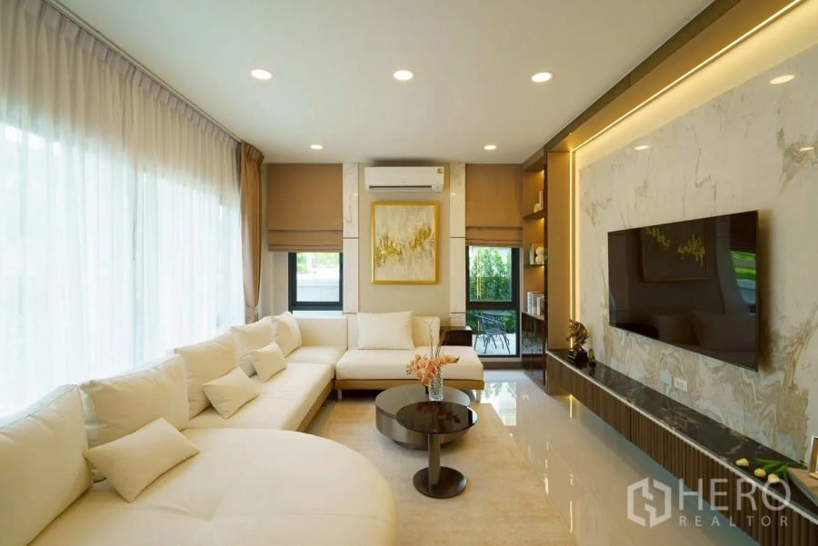 Detached House for sale in Bang Phli, Samut Prakan - Bright living area with a large sectional sofa and wide windows