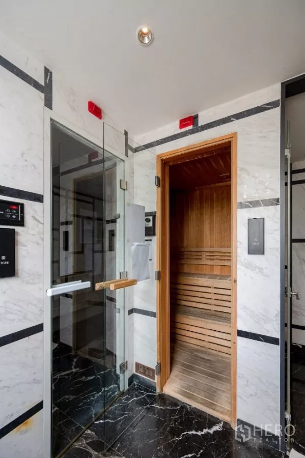 Condominium for rent or sale in Khlong Toei, Bangkok - Sauna and steam room area with glass door and wooden interior.
