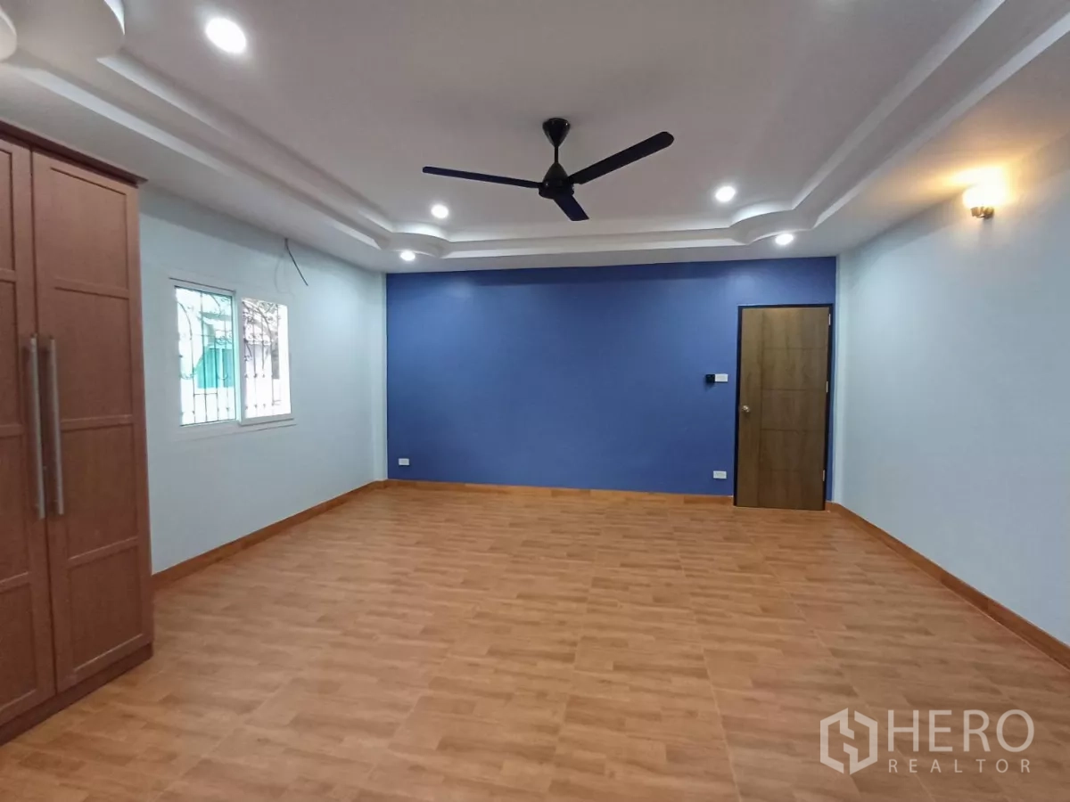 带办公室的家 出租在Phra Khanong, Bangkok - 大客厅/工作区，蓝色重点墙，吊扇，木纹地板。