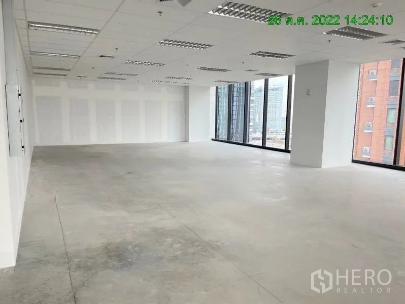 Office Space for rent in Ratchathewi, Bangkok - Spacious unfinished office floor featuring large corner glazing, white partition walls, and grid lighting.