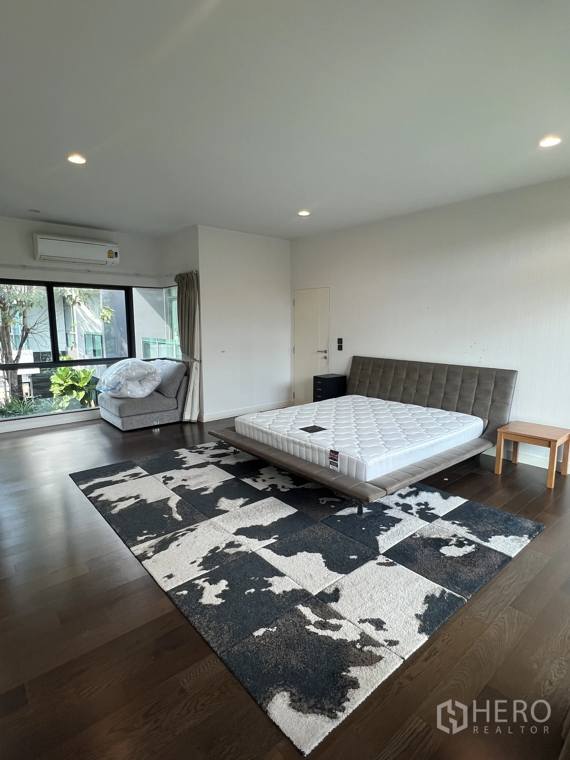 Detached House for rent in Bang Kapi, Bangkok - Spacious master bedroom with platform bed, large patterned area rug and picture windows.