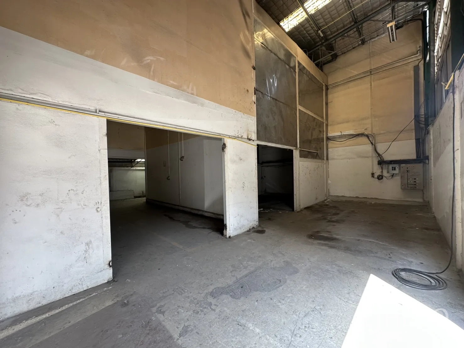 Warehouse for rent in Suan Luang, Bangkok - Tall service bay with sliding access to side rooms and exposed utility lines.